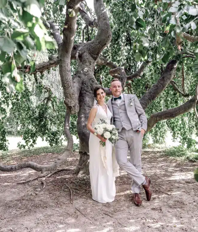 married couple leaning on a tree together